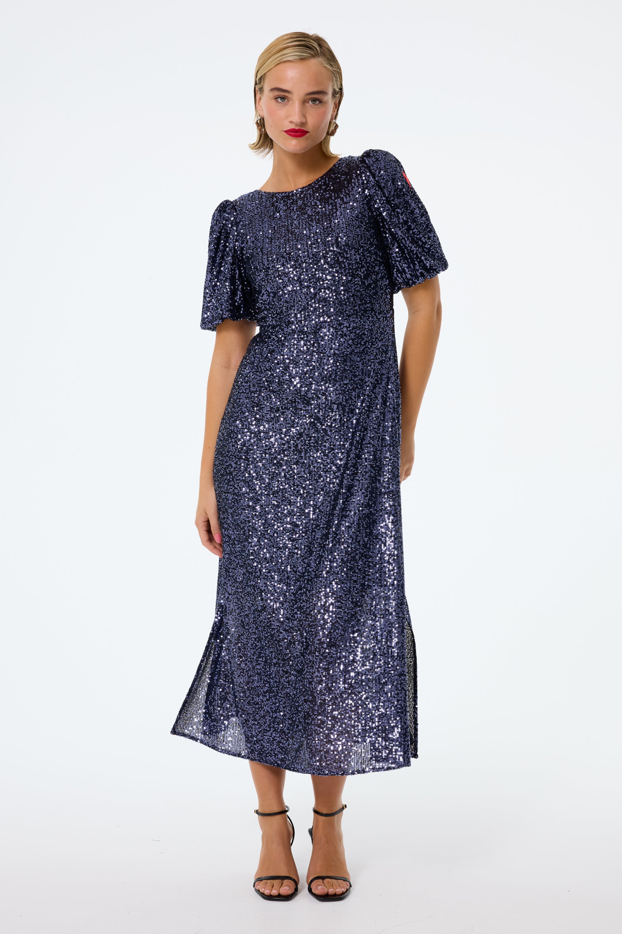 Scamp and Dude Navy Sequin Puff Sleeve Midi Dress | Model with straight hair wearing navy maxi sequin dress with black high heels 