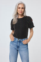 Scamp and Dude Black with Rainbow Lurex Stripe Puff Sleeve Top | Model wearing light blue distressed jeans with a black puff sleeve top featuring rainbow lurex stripe detail.