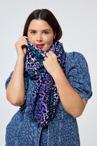 Scamp and Dude Blue with Green and Lilac Spliced Leopard Charity Super Scarf | Model wearing a leopard denim midi dress with a blue and green spliced print super scarf.