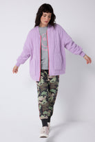 Scamp and Dude Lilac Organic Cotton Quilted Lightning Bolt Oversized Bomber Jacket | Model wearing a pair of khaki camo joggers with a lilac bomber jacket.