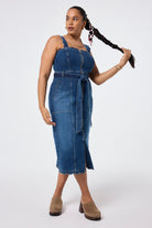 Scamp and Dude Indigo Wash Scallop Strappy Denim Sundress | Model wearing an indigo wash denim dress with scallop detail featuring a zip front closure and tie waist detail.