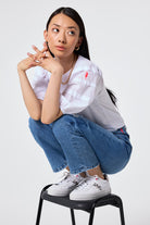 Air & Grace x Scamp & Dude White and Print Platform Trainers | Model wearing blue jeans and a white t-shirt with white and print platform trainers.