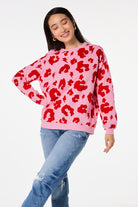 Scamp and Dude Pink with Red Mega Leopard Oversized Sweatshirt | Model wearing a pink crew neck sweatshirt in an oversized fit with red mega leopard and lightning bolt print.