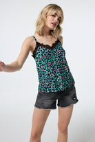 Scamp and Dude Green with Pink and Black Shadow Leopard Lace Trim Cami Top | Model wearing green cami top with a lace trim paired with denim shorts.