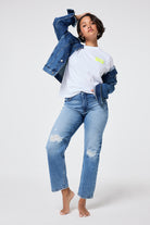 Scamp and Dude Authentic Light Indigo Distressed Straight Leg Jeans | Model wearing distressed blue denim jeans with a white graphic t-shirt and a denim jacket.