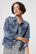 Scamp and Dude Authentic Indigo Trucker Denim Jacket | Model wearing a black and white cheetah print midi tea dress with a denim jacket over the top.