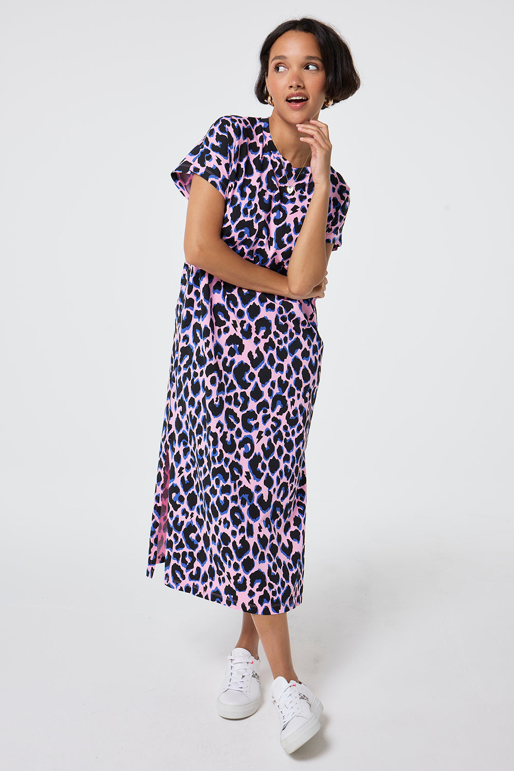 Scamp and Dude Pink with Blue and Black Shadow Leopard Midi T-Shirt Dress | Model wearing a pink midi t shirt dress in a blue and black leopard print featuring side split detail and worn with white trainers.