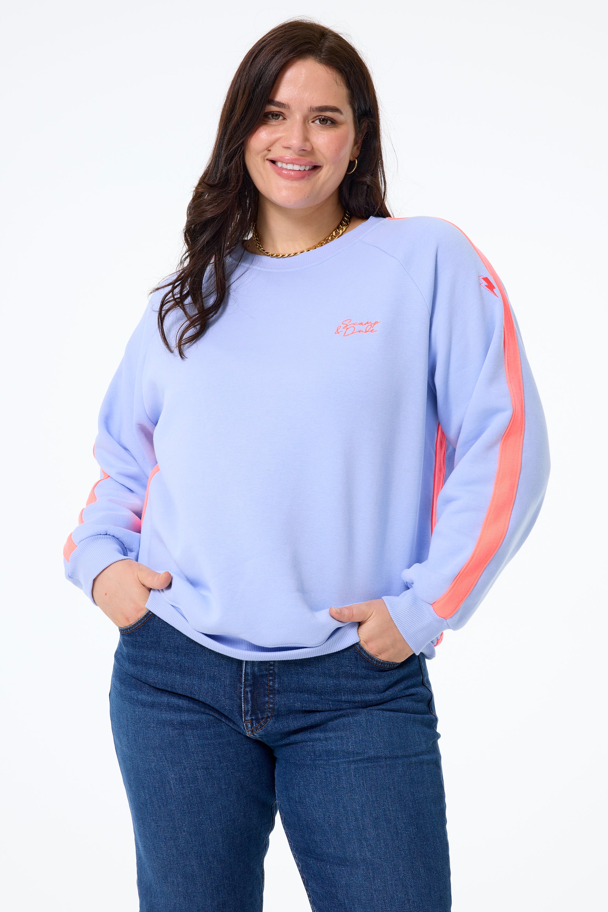 Scamp and Dude Lilac Blue with Neon Coral Colourblock Oversized Sweatshirt | Model wearing a lilac blue oversized sweatshirt featuring neon coral stripe detail paired with indigo denim jeans.