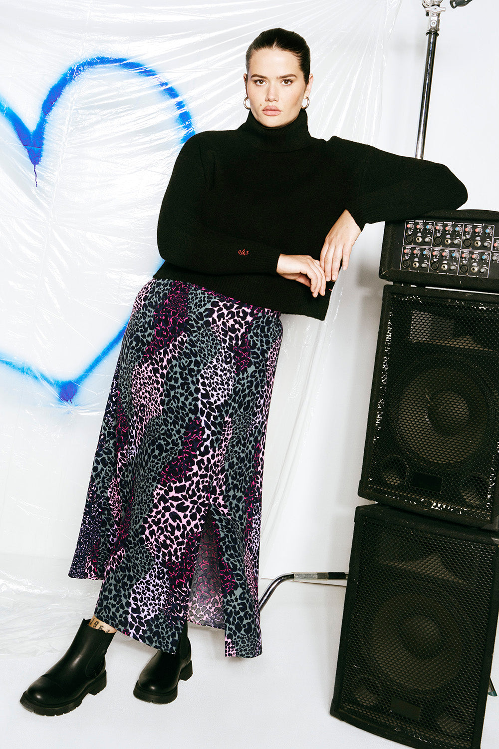 Scamp and Dude Khaki and Pink Spliced Leopard Split Front Skirt | Model wearing a split front midi skirt in a spliced leopard print paired with a black turtle neck knit jumper and black chunky boots.